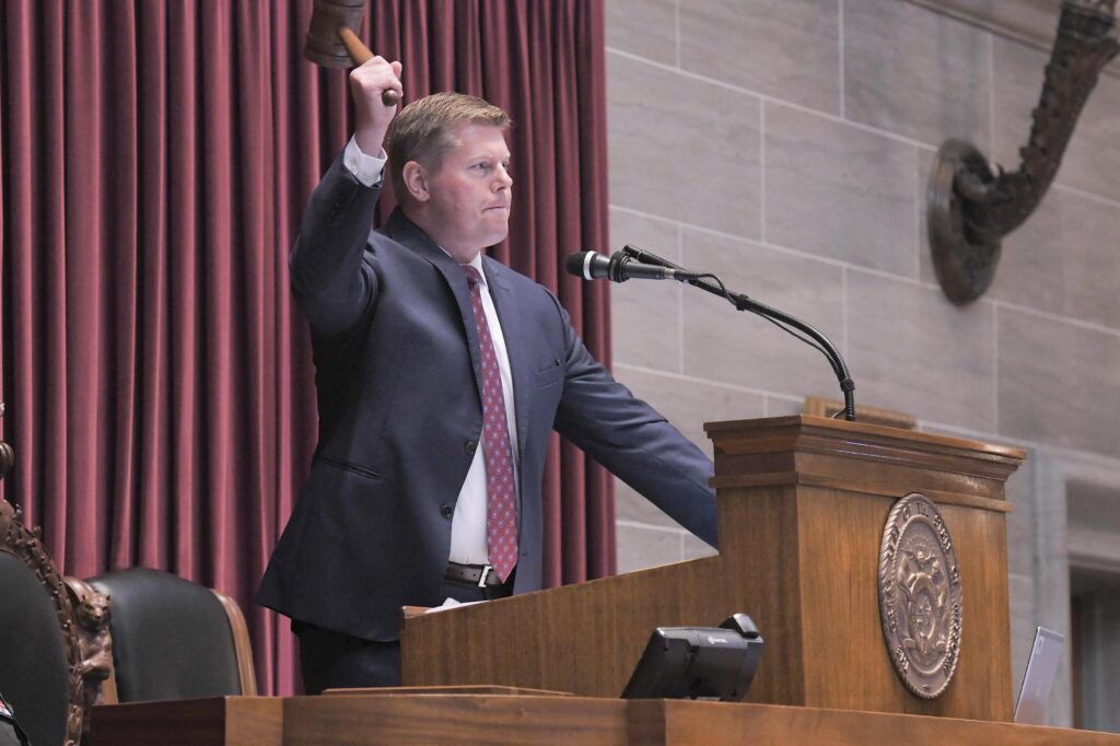 Dean Plocher raises the speaker gavel above his head.